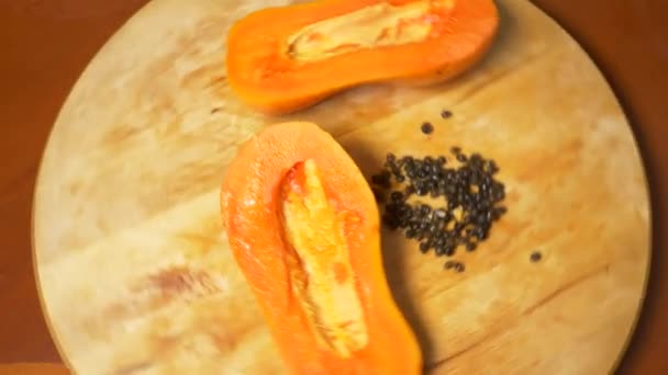 Екзотичні фрукти на столі. 4k, папайя, фрукти нарізані шматочками, обертаються на обробній дошці . — стокове відео