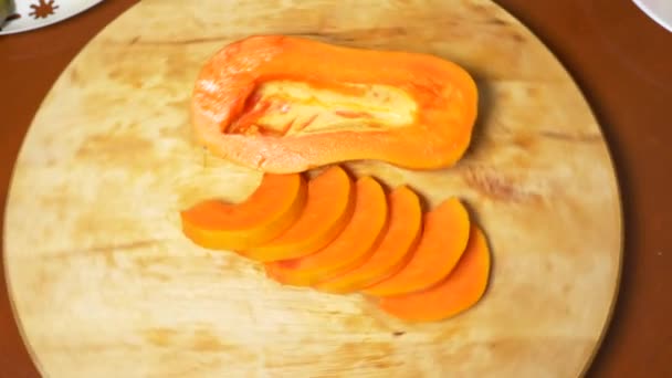 Εξωτικά φρούτα στο τραπέζι. 4k, papaya, φρούτα κομμένα σε κομμάτια, περιστροφή σε ένα ξύλο κοπής. — Αρχείο Βίντεο