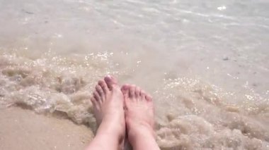 kadın ayakları üzerinde kum dalga deniz kadın bacakları kapsar. 4k, ağır çekim
