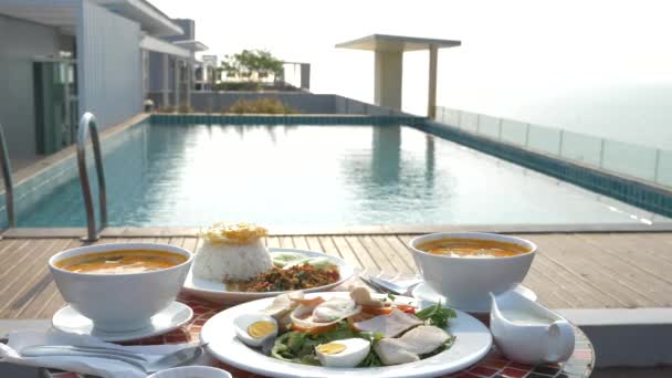 タイ料理の料理。プールで 4 k. テーブル。プール、フォーカスの変更によってタイの伝統的なランチ — ストック動画