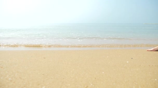 Pés masculinos na areia, a onda do mar cobre as pernas femininas. 4k, câmera lenta — Vídeo de Stock