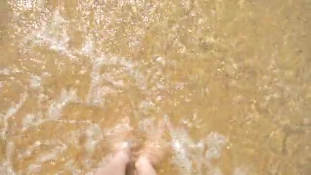 Pies femeninos en la arena, la ola marina cubre las piernas femeninas. 4k, cámara lenta — Vídeos de Stock