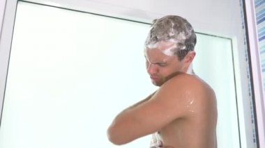 4k, ağır çekim. yakışıklı genç bir duş alır.