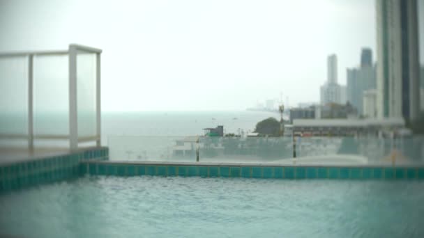 Aproape de apa din piscina de pe acoperiș pe fundalul zgârie-nori de ocean. 4k, blur fundal — Videoclip de stoc