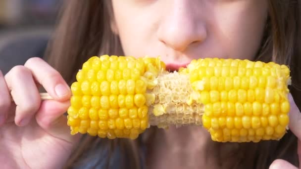 Joven chica divertida adolescente comiendo un maíz hervido. 4k, cámara lenta, primer plano . — Vídeo de stock