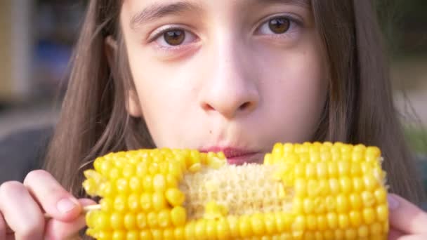Jeune fille drôle adolescent mangeant un maïs bouilli. 4k, ralenti, gros plan . — Video