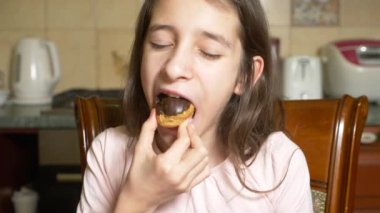 Kız teen keyifle çikolatalı pasta yiyor. 4k, ağır çekim