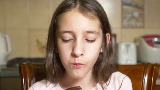 Girl teen eats chocolate eclair with pleasure. 4k, slow motion — Stock Video