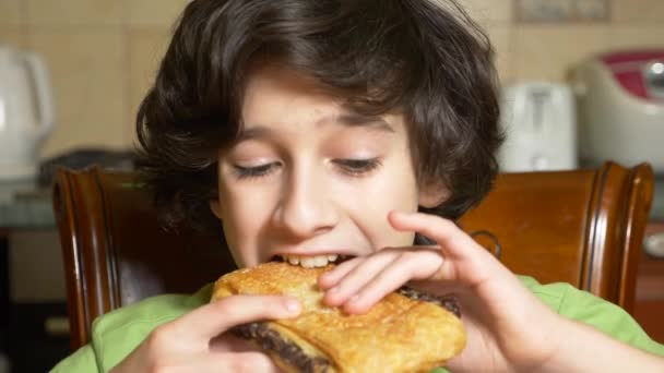 Мальчик-подросток с удовольствием ест шоколадную закуску. 4k, slow motion — стоковое видео