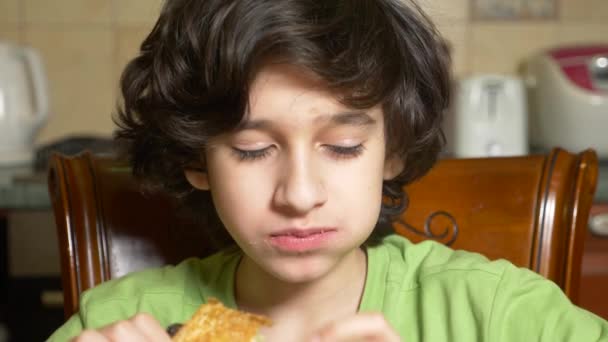 Garçon adolescent mange chocolat bouffée collation avec plaisir. 4k, au ralenti — Video