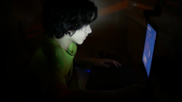 garçon utilise un ordinateur portable dans une pièce sombre, 4k ,