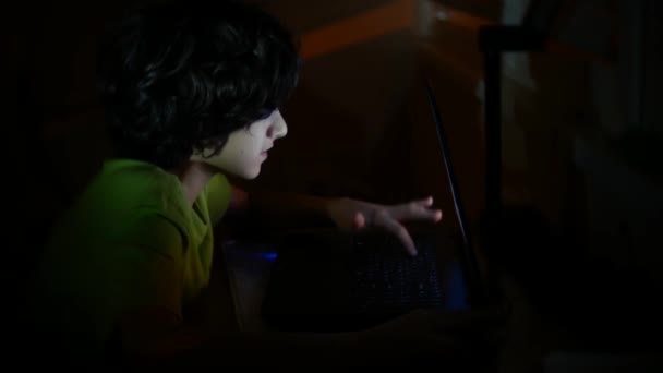 少年は暗い部屋、4 k でノート パソコンを使用してください。, — ストック動画