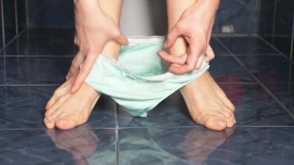 Ноги чоловіка, який сидить у туалеті з болем у животі. 4k, крупним планом — стокове відео