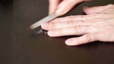 Resim tırnaklar manikür. bir kadının tırnaklarını koyu ahşap bir masa üzerinde kapalı testereleri. 4 k, yakın çekim, ağır çekim