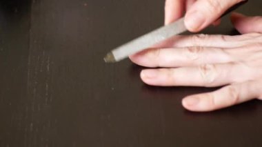Resim tırnaklar manikür. bir kadının tırnaklarını koyu ahşap bir masa üzerinde kapalı testereleri. 4 k, yakın çekim, ağır çekim