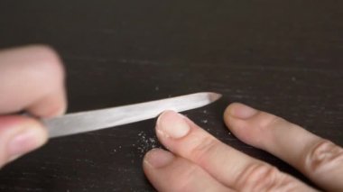 Resim tırnaklar manikür. bir kadının tırnaklarını koyu ahşap bir masa üzerinde kapalı testereleri. 4 k, yakın çekim, ağır çekim