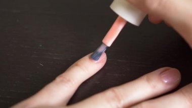 Kadın tırnaklarını pembe ojeyle boyuyor. 4k, yakın çekim, yavaş çekim