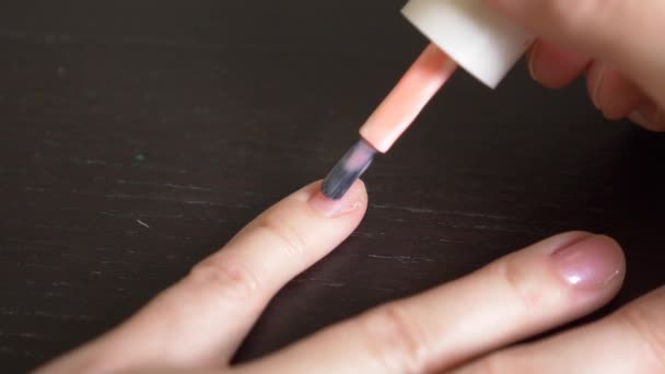 Mujer pintándose las uñas con esmalte de uñas rosa. 4k, primer plano, cámara lenta — Vídeo de stock