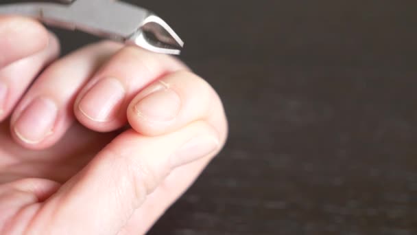 Vrouwelijke handen manicure sluiten van weergave. Snijden de bramen. een vrouw doet zelf een manicure met behulp van nagelknipper. 4 k, close-up, slow-motion — Stockvideo