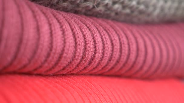 Knitten things. Sweaters are lying a pile. 4k, close-up, slow-motion, cozy seasonal background — Stock Video