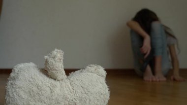 depresyon umutsuz bir çocuk odası duvar oturur, intihar girişimi çalışır. Bu yanındaki terk edilmiş bir yumuşak oyuncak var. 4k, ağır çekim.