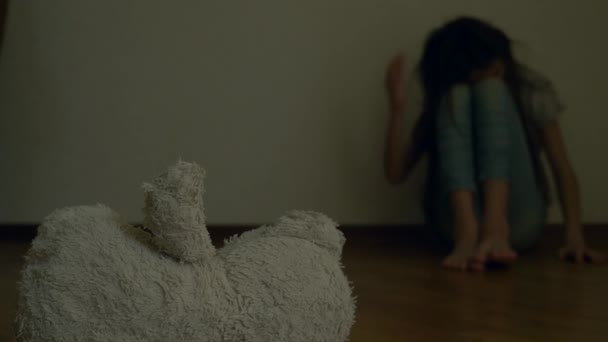 우울증에 절망적 인 아이, 자살 시도 하려고 그의 방의 벽에 앉는 다. 옆은 버려진된 부드러운 장난감입니다. 4 k, 슬로우 모션. — 비디오