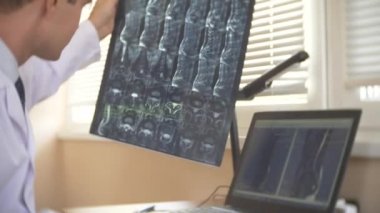 Doktor, hasta MRI makinesinde hareket ederken bilgisayar ekranına bakarak doktor onun laptop manyetik rezonans görüntüleme sonuçlarını analiz eder. 4k, arka plan bulanıklık