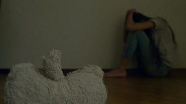 depresyon umutsuz bir çocuk odası duvar oturur, intihar girişimi çalışır. Bu yanındaki terk edilmiş bir yumuşak oyuncak var. 4k, ağır çekim.