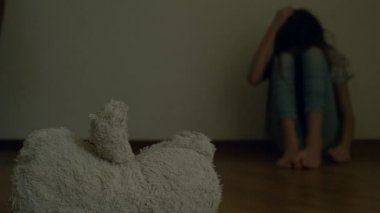 depresyon umutsuz bir çocuk odası duvar oturur, intihar girişimi çalışır. Bu yanındaki terk edilmiş bir yumuşak oyuncak var. 4k, ağır çekim.