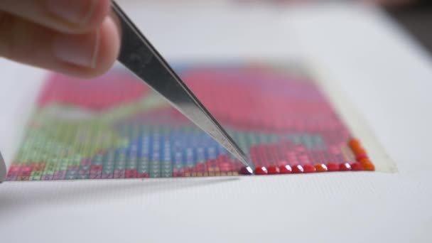 The mosaic process, the girls hand holding tweezers, making a mosaic. 4k, close-up — Stock Video