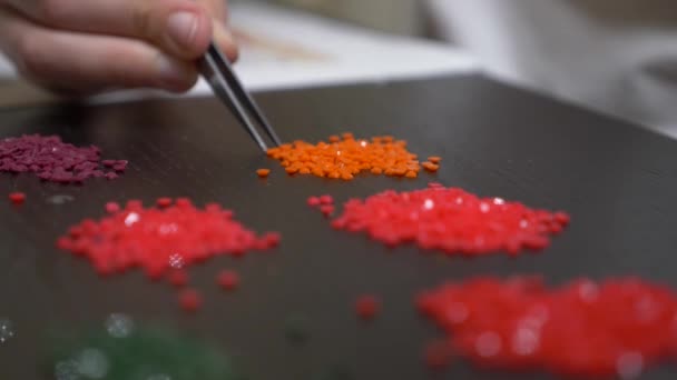 The mosaic process, the girls hand holding tweezers, making a mosaic. 4k, close-up — Stock Video