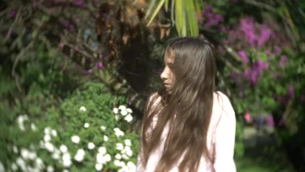 Retrato de uma menina olhando para a câmera no parque de verão. 4K. Movimento lento — Vídeo de Stock