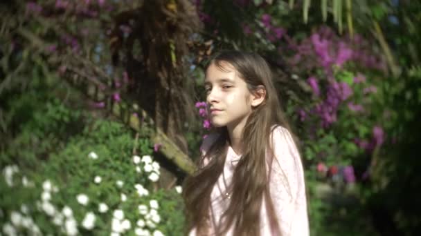 Retrato de uma menina olhando para a câmera no parque de verão. 4K. Movimento lento — Vídeo de Stock