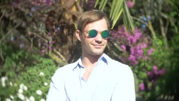 Anak muda mengenakan kacamata luar ruangan jempol atas, di taman siang hari matahari ligan, 4k, gerak lambat — Stok Video