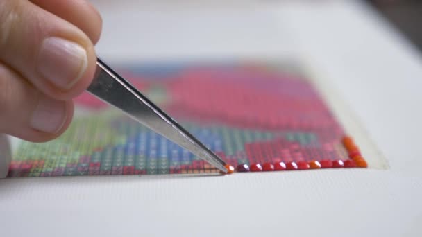 The mosaic process, the girls hand holding tweezers, making a mosaic. 4k, close-up — Stock Video