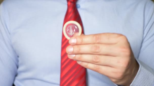 4 k, Slowmotion, närbild. manliga händer håller en kondom. Begreppet säker sex och preventivmedel. — Stockvideo