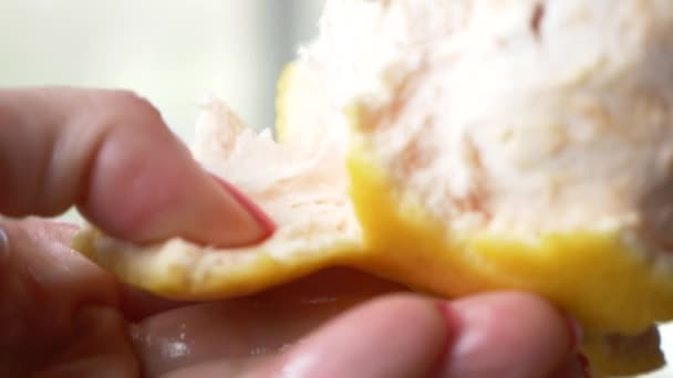 Las manos femeninas limpian el pomelo. 4k, primer plano, cámara lenta — Vídeo de stock