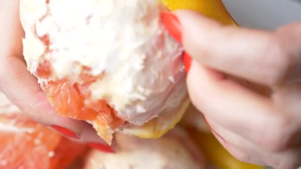 Жіночі руки очищають грейпфрут. 4k, крупним планом, повільний рух — стокове відео