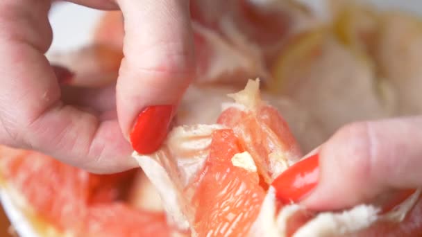 Женские руки очищают грейпфрут. 4k, крупный план, замедленная съемка — стоковое видео