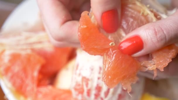 Las manos femeninas limpian el pomelo. 4k, primer plano, cámara lenta — Vídeos de Stock