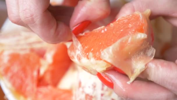 Kvinnliga händer rengör grapefrukt. 4 k, närbild, slow motion — Stockvideo