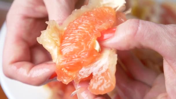 As mãos femininas limpam a toranja. 4k, close-up, câmera lenta — Vídeo de Stock