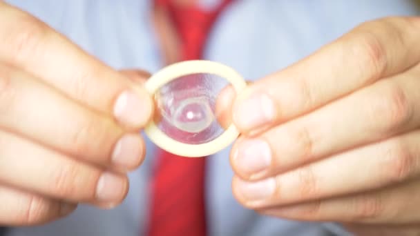 4К, замедленная съемка, крупный план. Мужские руки держат презерватив. Концепция безопасного секса и контрацепции . — стоковое видео