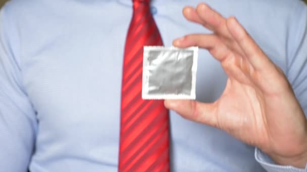 4k, cámara lenta, primer plano. Manos de hombre sostienen un condón empaquetado. El concepto de sexo seguro y anticoncepción . — Vídeo de stock