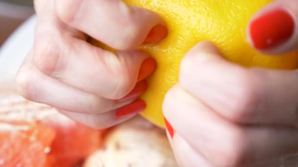 Γυναικεία χέρια καθαρίσει το γκρέιπφρουτ. 4 k, γκρο πλαν, αργή κίνηση — Αρχείο Βίντεο