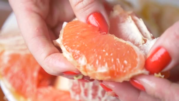 Las manos femeninas limpian el pomelo. 4k, primer plano, cámara lenta — Vídeos de Stock