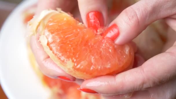 Las manos femeninas limpian el pomelo. 4k, primer plano, cámara lenta — Vídeos de Stock