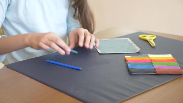 La ragazza seduta a tavola, disegna diverse figure dal modello di colore plastilina. Sviluppo di modelli artistici nei bambini. 4k, primo piano, rallentatore — Video Stock