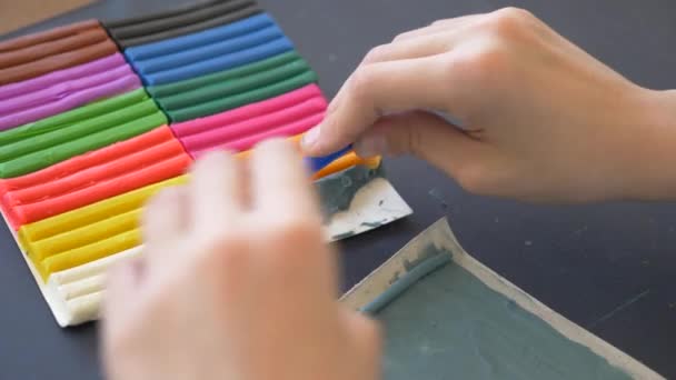 Девушка, сидящая за столом, рисует разные фигуры из пластилина цветовой модели. Развитие художественного моделирования у детей. 4k, крупный план, замедленная съемка — стоковое видео