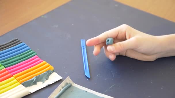 La ragazza seduta a tavola, disegna diverse figure dal modello di colore plastilina. Sviluppo di modelli artistici nei bambini. 4k, primo piano, rallentatore — Video Stock